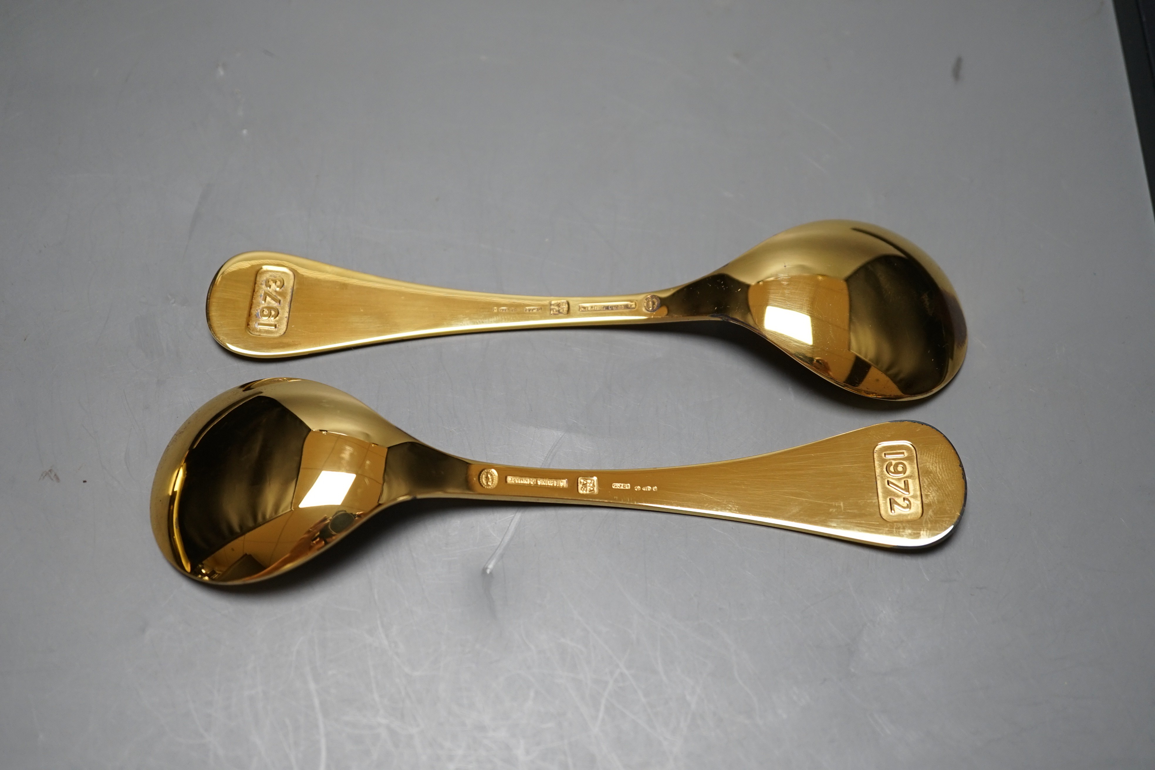 A Georg Jensen gilt sterling 1972 'Cornflower' spoon, 14.9cm and a similar Georg Jensen 1973 spoon, with box or pouch.